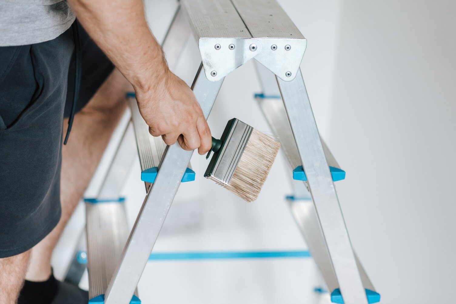 a man painting house wall