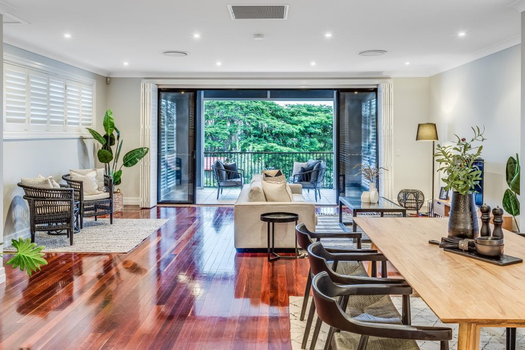 Looking down the center line of a home with beautiful wood floors leading out to a balcony