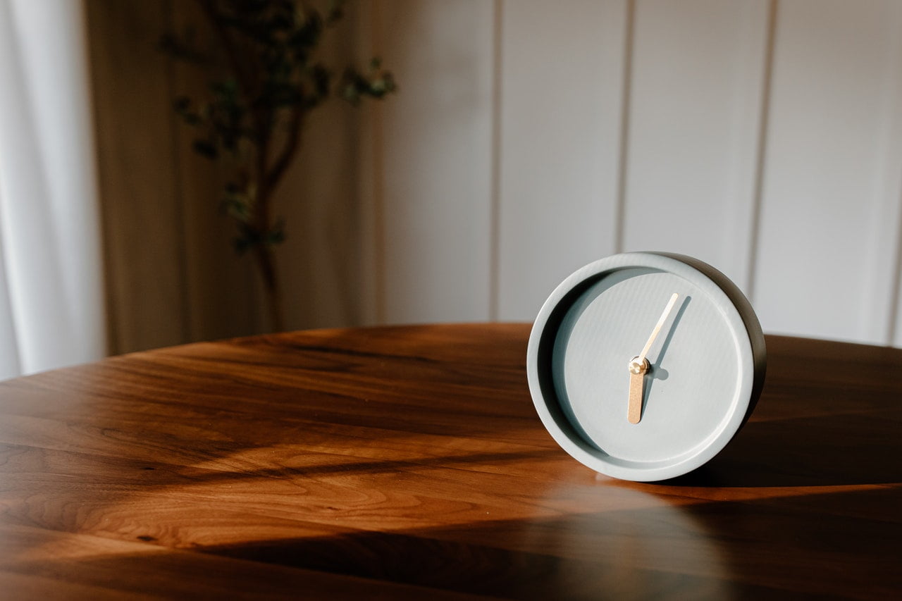 a clock on a wooden table