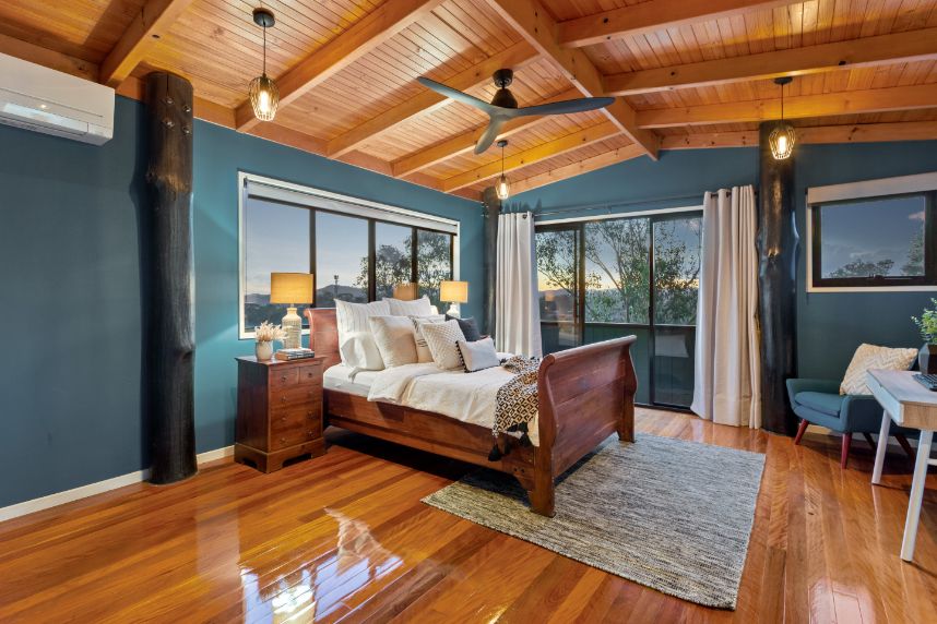 A bed in a room with wooden floors