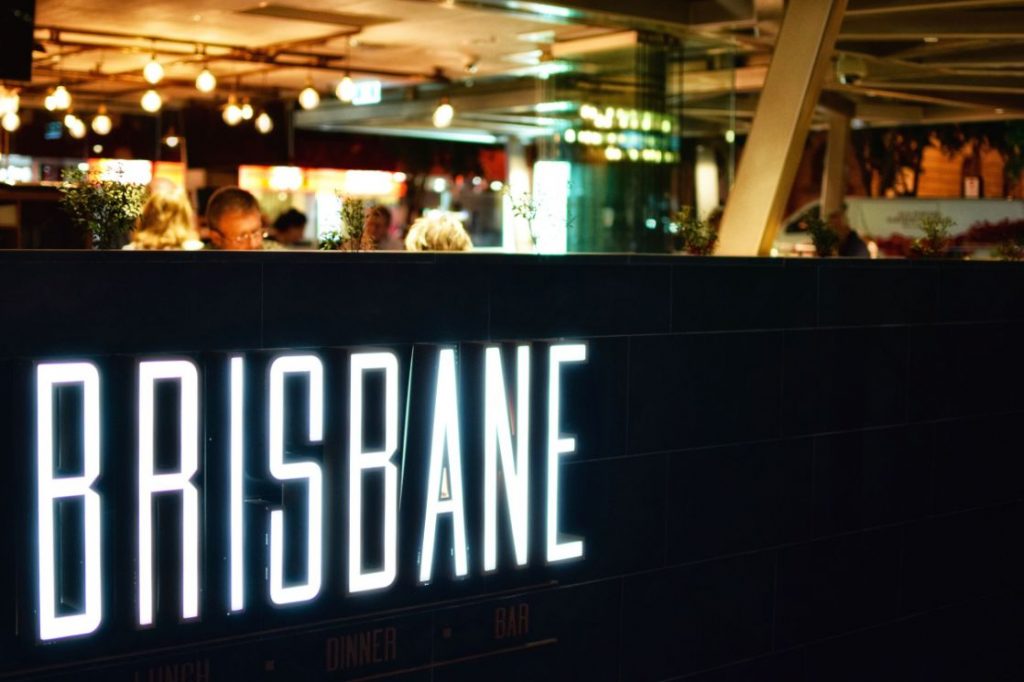 Neon Brisbane sign next to restaurant