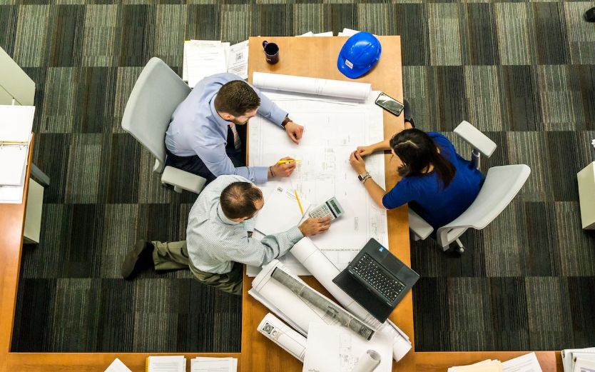Arial view of coworkers sitting at a desk with papers